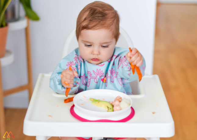 niemowlę samodzielnie je frytki z pieczonych warzyw