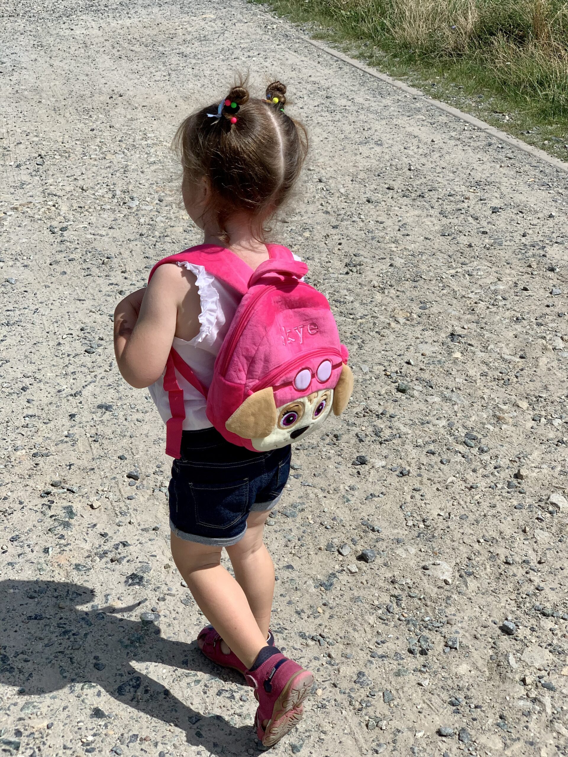 dziewczynka z plecakiem idzie do przedszkola
